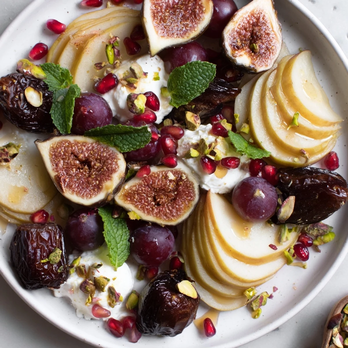 Snowdrift Platter: A vibrant winter fruit arrangement with figs and dates, finished with snowy coconut flakes.