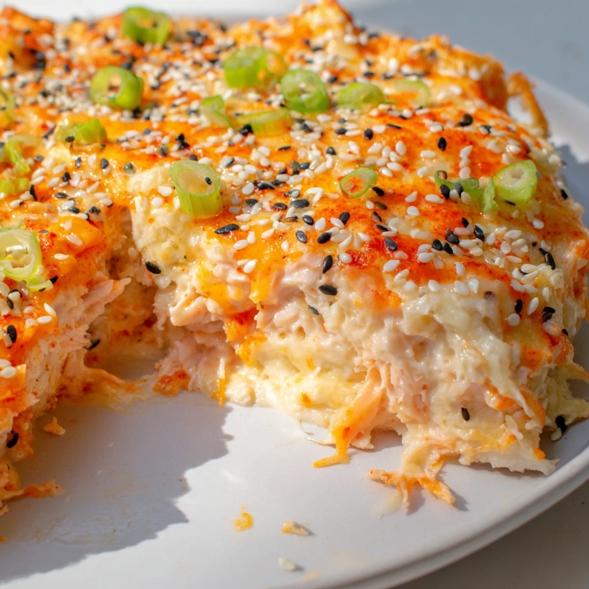 Creamy Salmon Sushi Bake topped with melted cheese, glistening and ready to serve with nori.