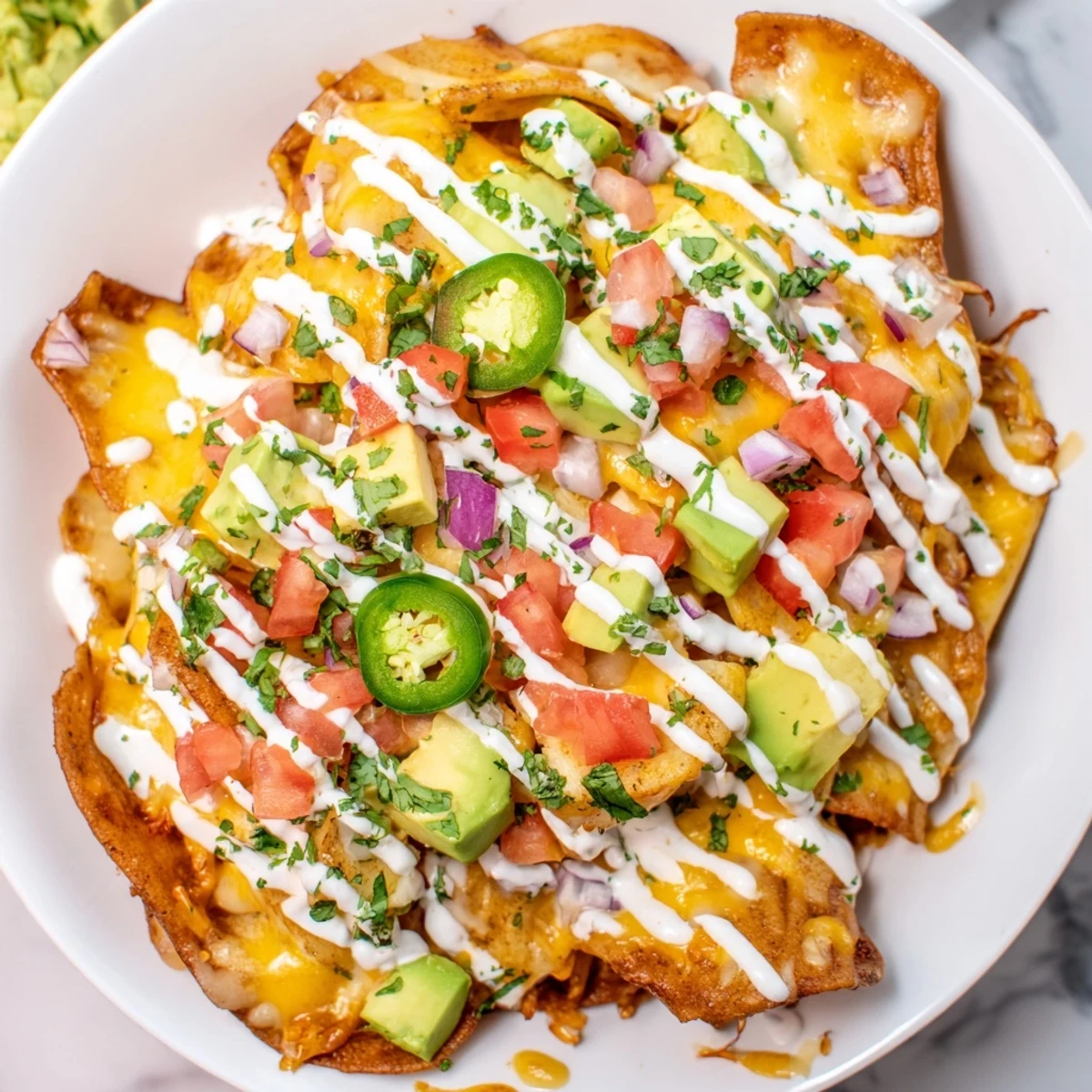Golden, bubbly Pasta Chips Nachos loaded with melted cheese, fresh toppings, and a creamy sauce.
