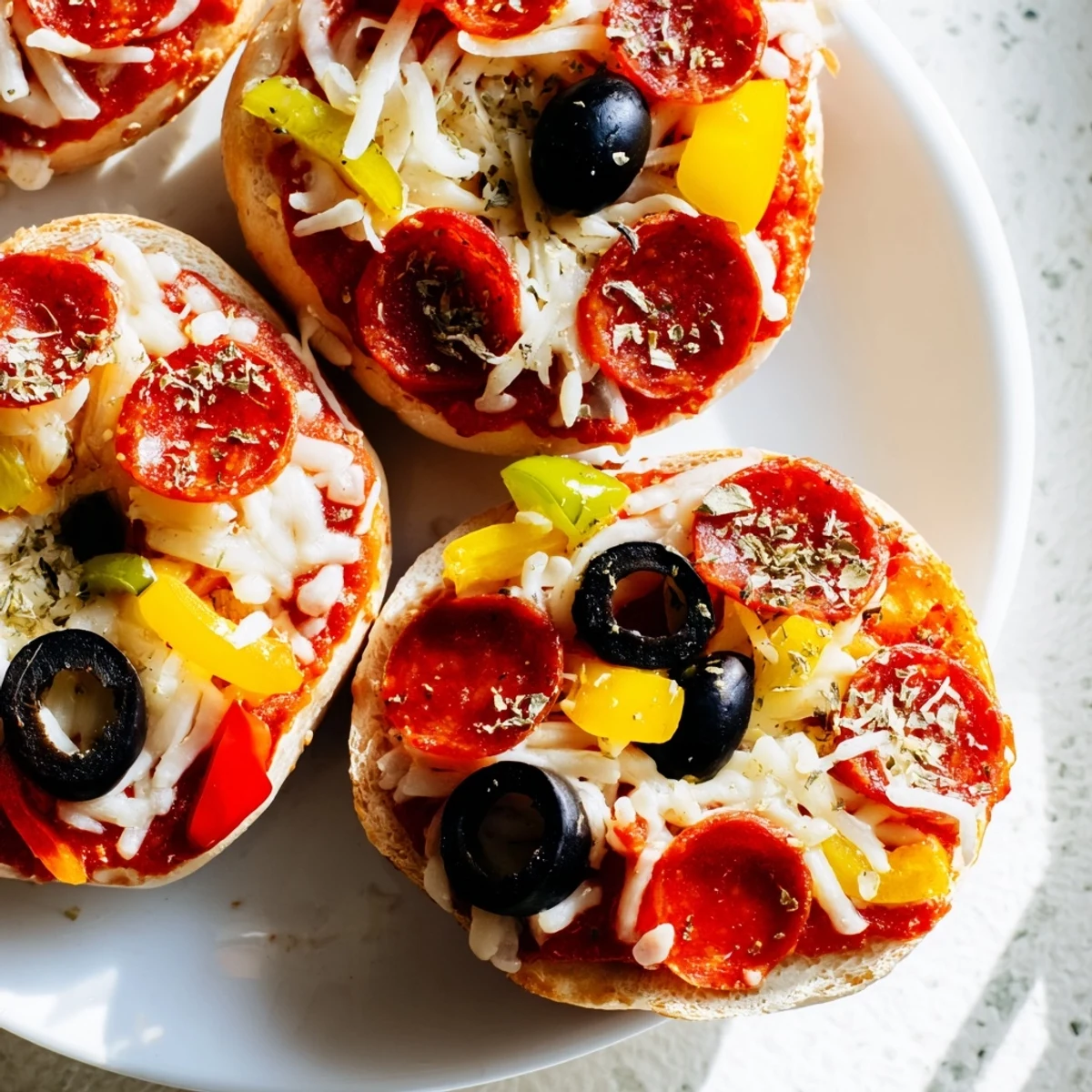 Close-up of freshly made mini bagel pizzas, a delicious, cheesy appetizer or party food.