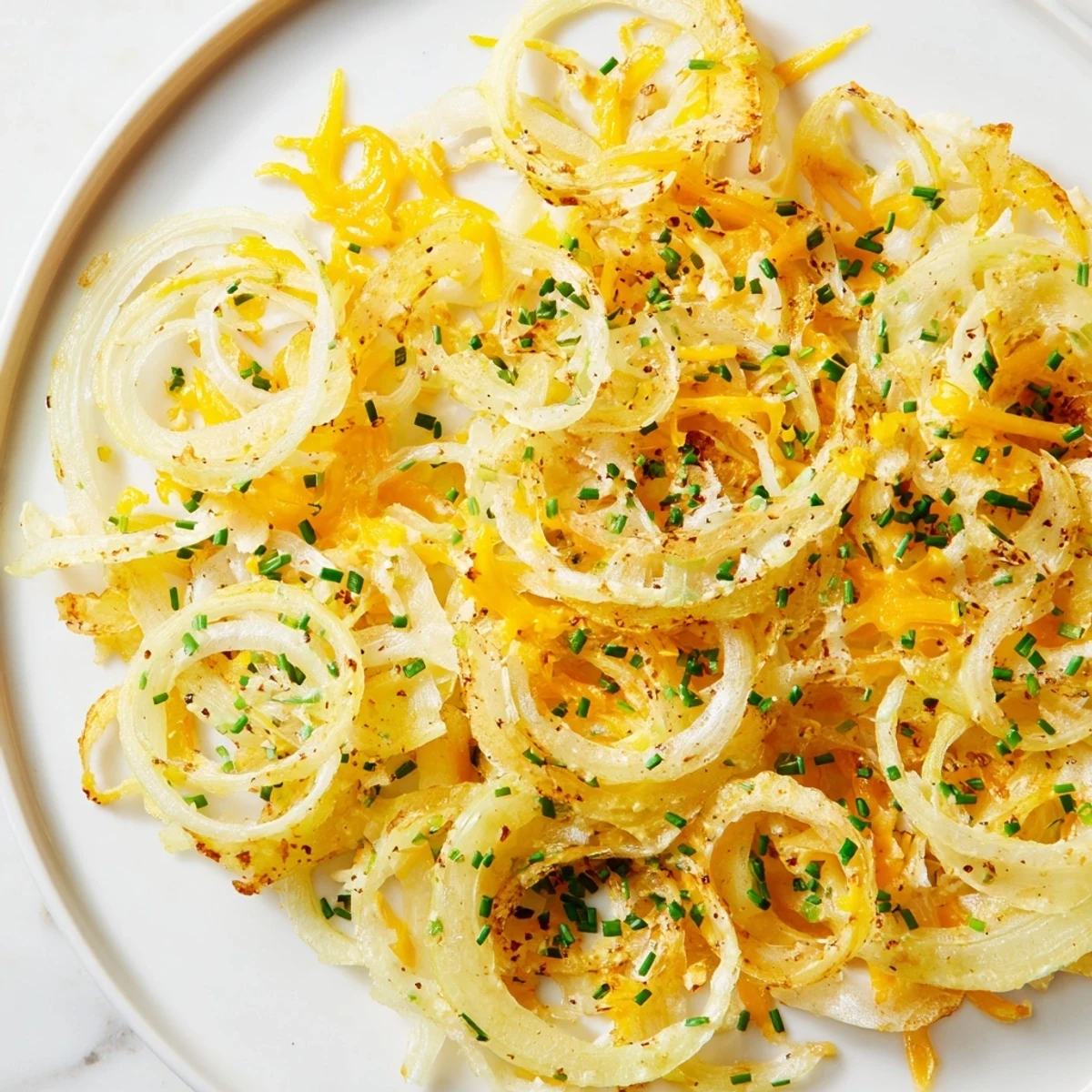 Golden, crispy Crispy Onion Cheese Chips with melted cheese and browning onion edges, perfect snack.