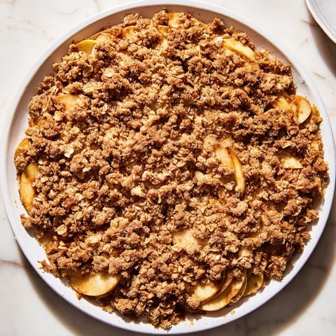 Warm Rustic Apple Cinnamon Crumble: golden, bubbly photo of a warm, comforting dessert, ideal with vanilla ice cream.