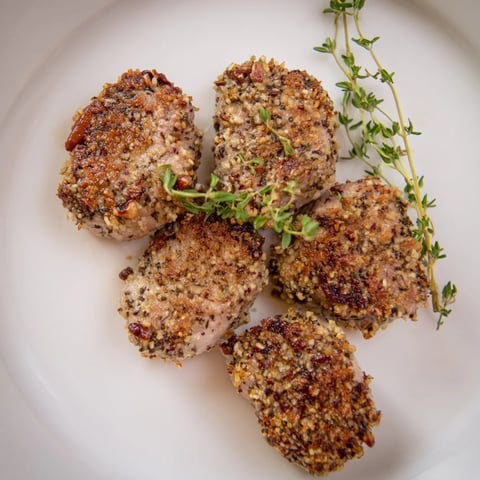 Golden-brown Thyme and Pecan Crusted Pork Tenderloin, ready to slice after perfect oven roasting in America.
