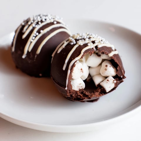 Cute Hot Chocolate Bombs with cocoa and mini marshmallows ready to melt in hot milk for a cozy treat.