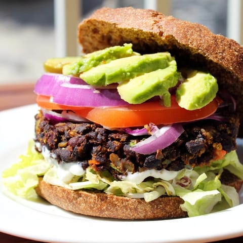 Golden-brown black bean burgers are stacked high with toppings, a delicious vegetarian meal for weeknights.