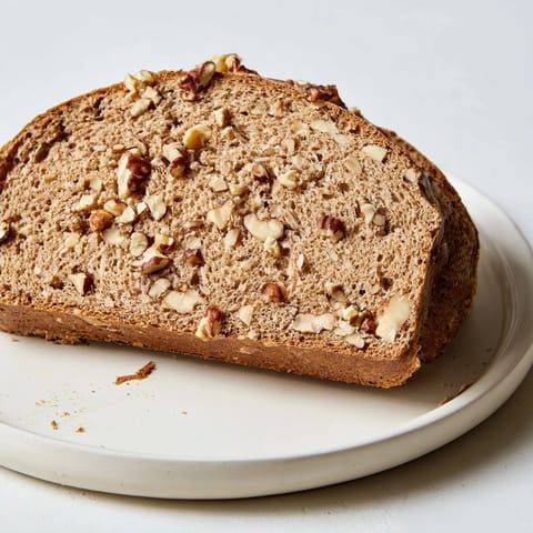 Freshly baked Nutty Whole Wheat Loaf Bread with a beautiful, textured crust and visible nuts throughout.