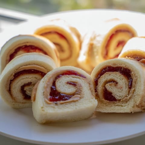 Colorful quartered PB&J pinwheel rolls, a delightful, easy snack for lunchboxes or a quick bite.