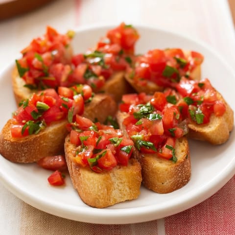 Golden toasted baguette slices form a diagonal line, topped with flavorful Bruschetta, a delightful Italian appetizer.