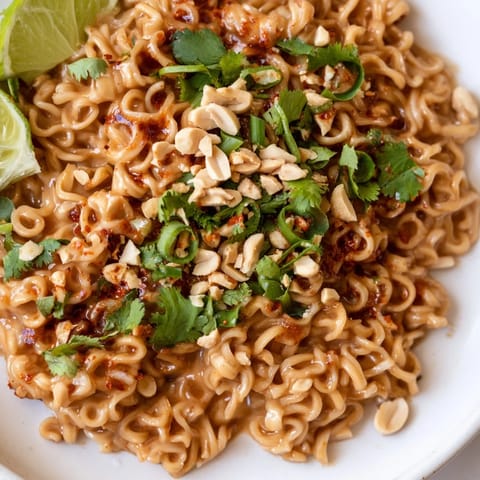 Vibrant plate of Instant Peanut Thai Sauce Noodles, garnished with peanuts and fresh cilantro, is ready to eat.
