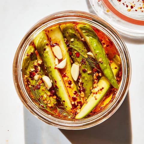 A close-up of Taco Pickles in a jar, marinated in vibrant spices, ready for snacking or topping burgers.