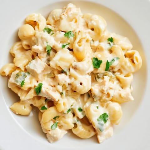 Topped with fresh cilantro, this creamy skillet Green Chili Chicken Mac features tender chicken and mild green chiles in a cheesy sauce.