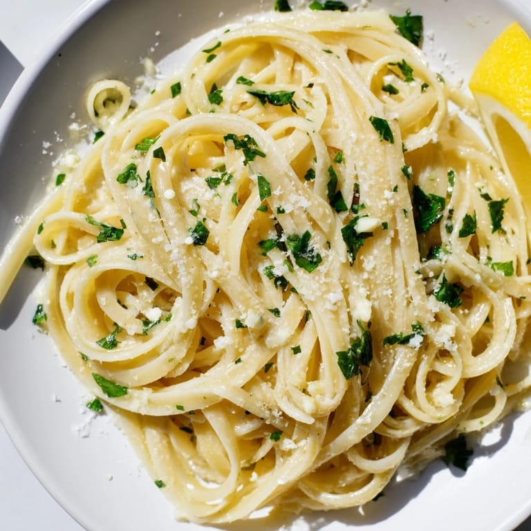 Close-up of perfectly cooked garlic butter linguine, enhanced with bright lemon zest and Parmesan.
