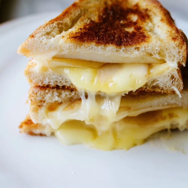 Served warm on a wooden board, this savory and sweet gourmet grilled cheese is ready to enjoy.
