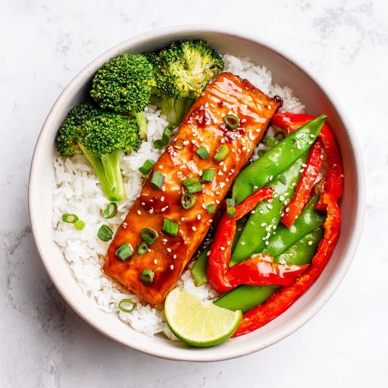 Perfectly cooked Maple Soy Glazed Salmon shines in a skillet, dripping with sweet and savory sauce over crisp-tender broccoli and peppers.