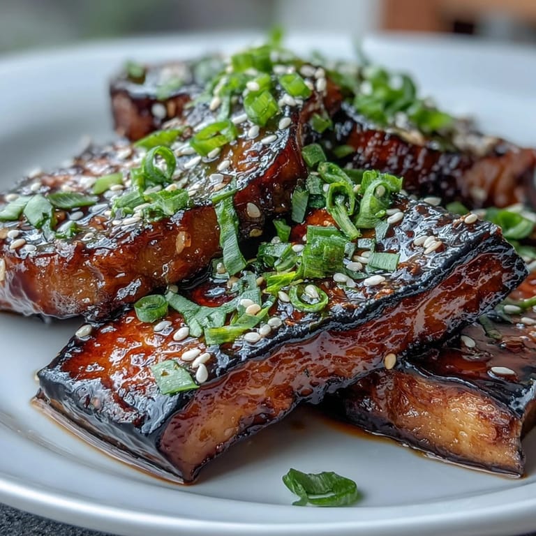 Tender eggplant slices brushed with sweet-salty miso glaze, roasted to silky perfection and garnished with sesame seeds and green onions.  